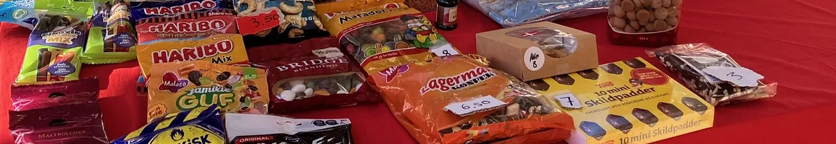 Et billede af slikposer og chokolade, der ligger på et bord med en rød dug