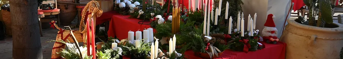 Et billede fra julebasaren i Den Danske Kirke i Sydfrankrig med en bod med adventskranse, og der er også en julebuk